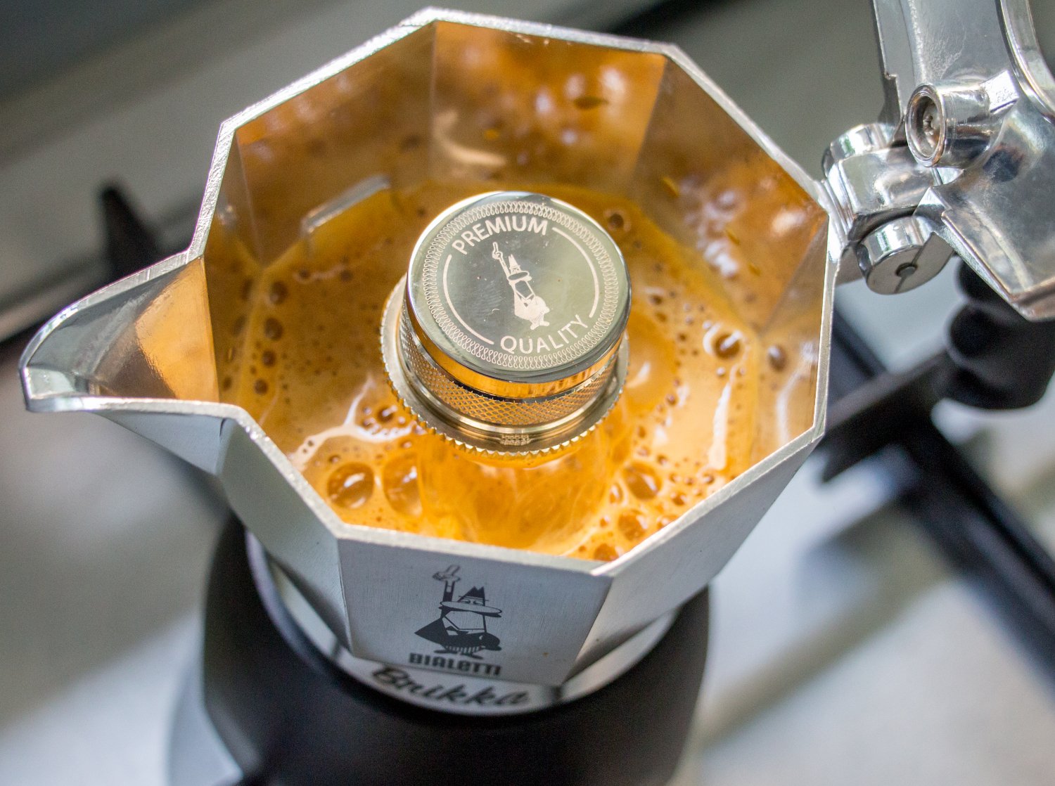 Bialetti Coffee maker image, shot from above, showing coffee being brewed. 