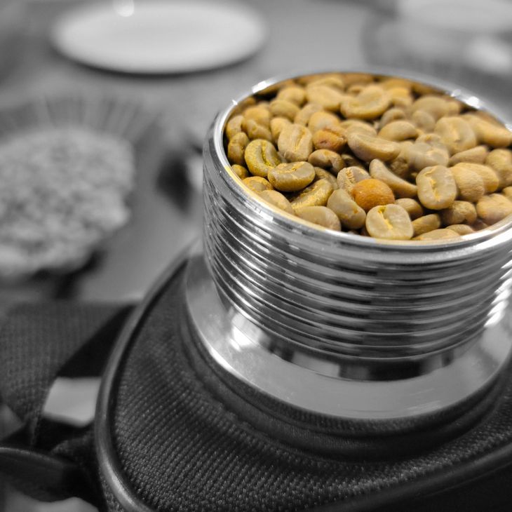 Green coffee beans shown inside a device that measures its moisture content. 