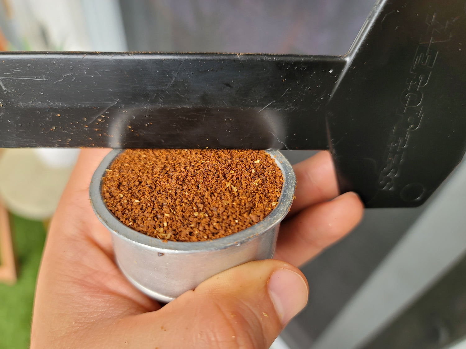 Coffee inside the basket being flattened out using an Aeropress stirrer. 